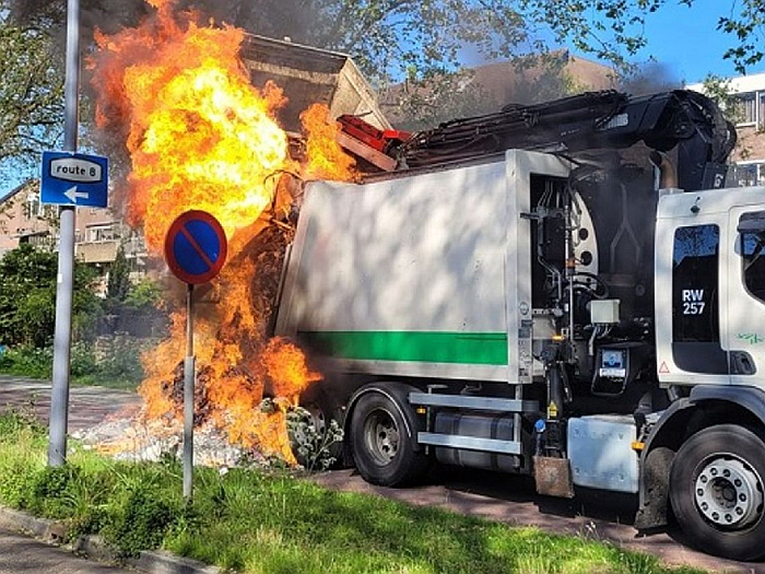 Pożar śmieciarki lub składowiska odpadów, z płomieniami i dymem, symbolizujący zagrożenie związane z wyrzucaniem e-papierosów do odpadów zmieszanych.