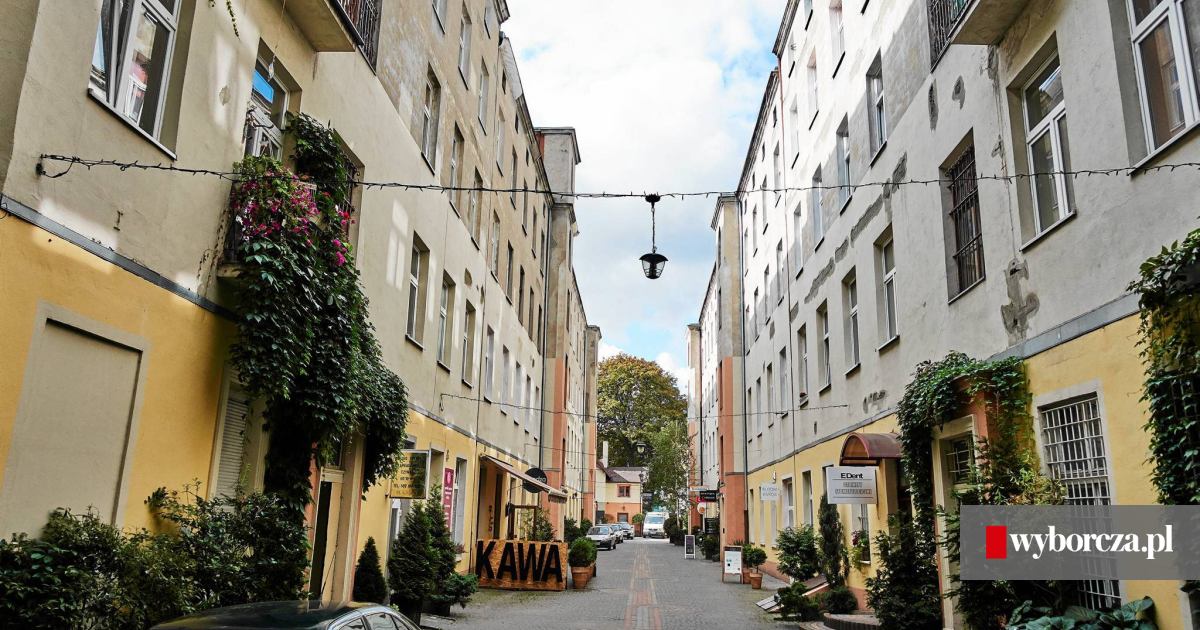 Młoda osoba używająca e-papierosa na tle ruchliwej ulicy Piotrkowskiej w Łodzi, symbolizująca zabiegany dzień i potrzebę niezawodnego urządzenia.